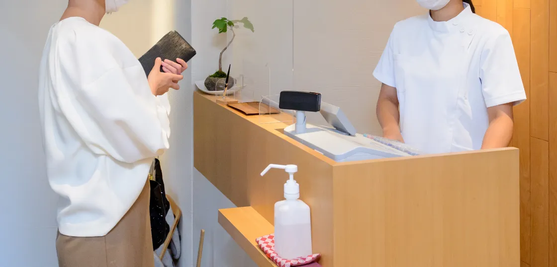 受付カウンターで会計手続きをしている女性